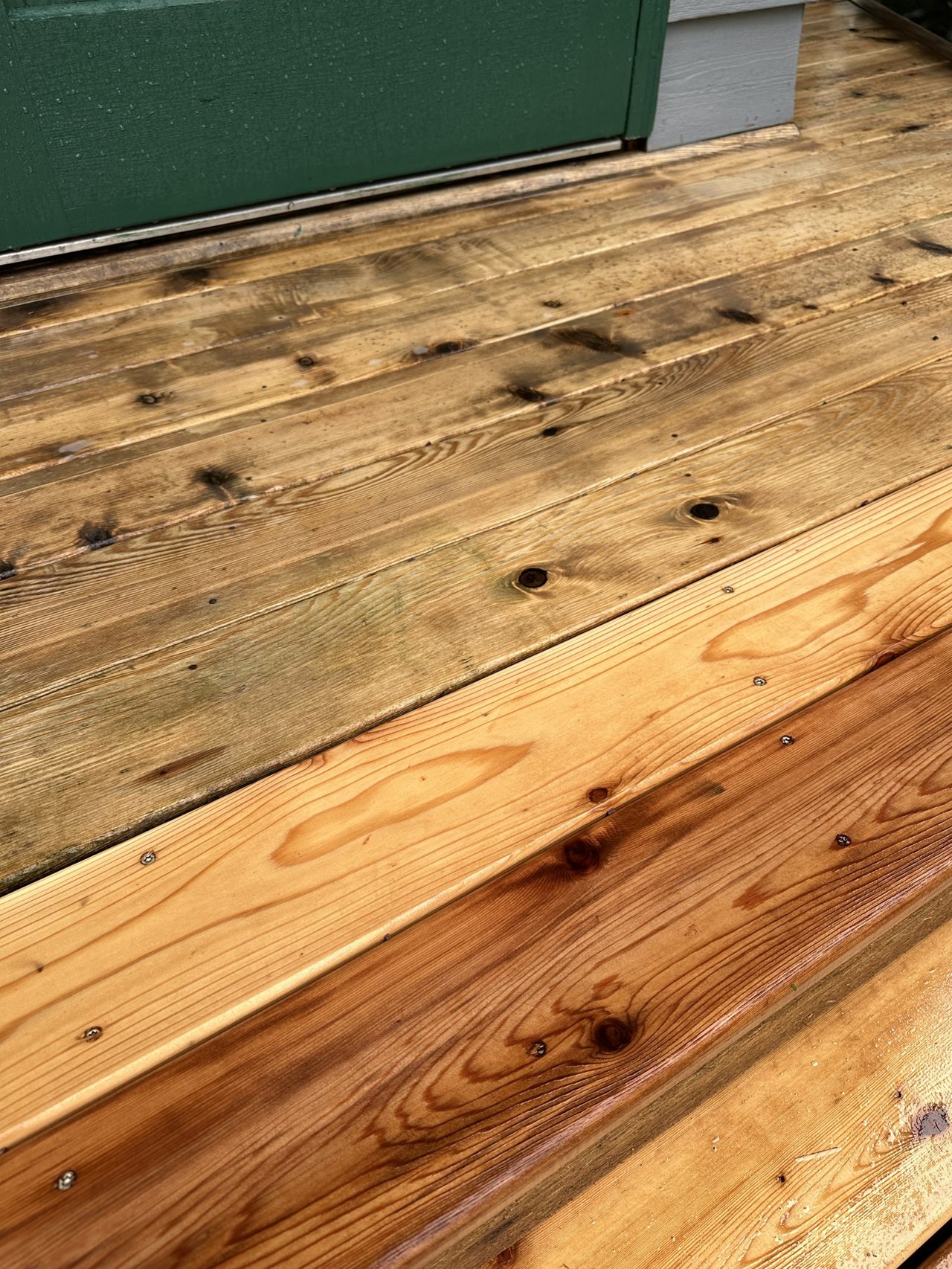 A wood deck part way through cleaning